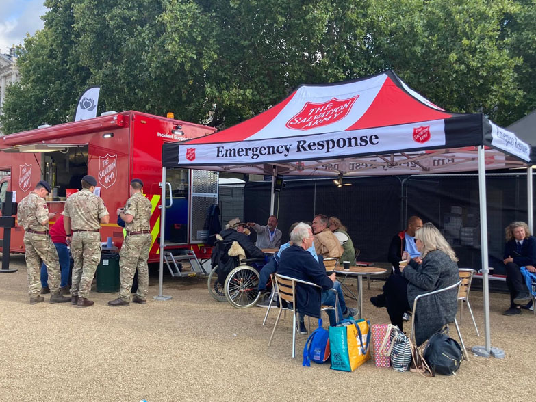 People sitting under a printed gazebo 
