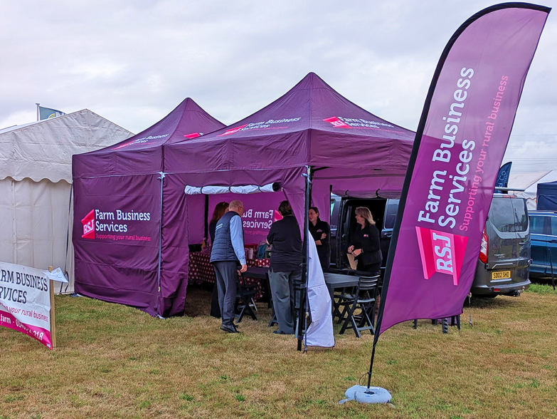 RSJ Farm Business Services purple branded gazebo with feather flag at Holsworthy Agricultural Show