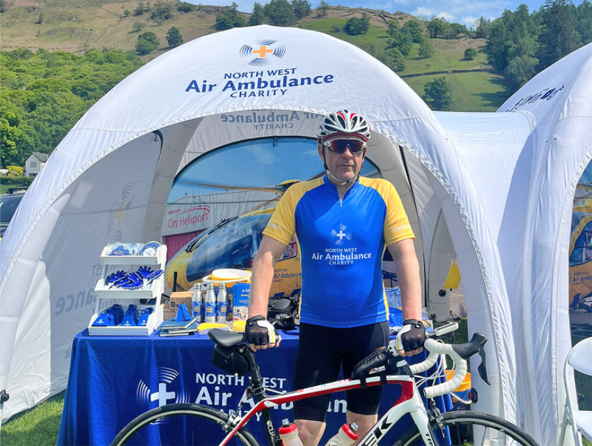 Cyclist in front of two connected North West Air Ambulance Charity Spider Dome X1s with custom tunnel